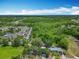 Wide aerial shot showcasing a home, lush greenery, surrounding apartments, and an expansive blue sky at 511 Doctors Dr, Oviedo, FL 32765
