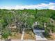 Overhead view of a single-story home featuring a front-facing garage and gravel walkway, surrounded by lush trees at 511 Doctors Dr, Oviedo, FL 32765