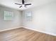 Bedroom featuring hardwood floors, two windows, and a modern ceiling fan at 511 Doctors Dr, Oviedo, FL 32765