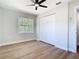 Bedroom with hardwood floors, large window, closet, and modern ceiling fan at 511 Doctors Dr, Oviedo, FL 32765