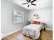 Cozy bedroom with wood floors, ceiling fan, window, and stylish decor at 511 Doctors Dr, Oviedo, FL 32765