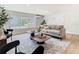 Comfortable living room with a large window, neutral-toned sofa, stylish rug, and contemporary decor at 511 Doctors Dr, Oviedo, FL 32765