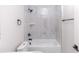 Bathroom featuring white tile surround, white tub, black fixtures and white toilet at 544 E Voorhis Ave, Deland, FL 32724