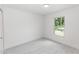 A bright, empty bedroom with white walls, gray wood-look floors, and a window at 544 E Voorhis Ave, Deland, FL 32724