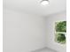 An empty bedroom with white walls, gray wood-look floors, and a window at 544 E Voorhis Ave, Deland, FL 32724