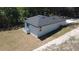 Exterior angle of a home with neutral siding, a dark roof, a small deck, and minimal landscaping at 544 E Voorhis Ave, Deland, FL 32724