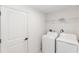 Bright laundry room with white appliances, shelving and tile flooring at 544 E Voorhis Ave, Deland, FL 32724