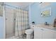 Bathroom featuring shower, toilet, and sink with blue walls at 5496 S Nova Rd, Port Orange, FL 32127