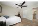 Cozy bedroom features wood-look flooring, ceiling fan and a double door closet with an ensuite bath at 5496 S Nova Rd, Port Orange, FL 32127