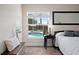 Bedroom view with window overlooking the pool, dark wood floors, and minimalist decorations at 5496 S Nova Rd, Port Orange, FL 32127