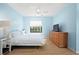 Cozy bedroom with a comfortable bed, a TV atop a dresser, and natural light streaming through the window at 5496 S Nova Rd, Port Orange, FL 32127