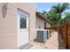 Side exterior view of the home, featuring a side door, air conditioning units, and a pathway to the backyard at 5496 S Nova Rd, Port Orange, FL 32127