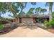 Single-story brick home with mature tree, driveway, and two-car garage at 5496 S Nova Rd, Port Orange, FL 32127