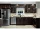 Modern kitchen showcasing stainless steel appliances and dark custom cabinets at 5496 S Nova Rd, Port Orange, FL 32127