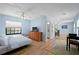 Spacious main bedroom with a comfortable bed, a TV atop a dresser, and an adjacent dining area at 5496 S Nova Rd, Port Orange, FL 32127