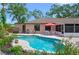 A tranquil backyard showcasing a refreshing pool surrounded by beautiful landscaping and comfortable seating area at 5496 S Nova Rd, Port Orange, FL 32127