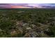 Expansive neighborhood featuring lush tree coverage beneath a colorful sky at dusk at 560 Sumner Ave, Orange City, FL 32763