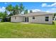View of the home's backyard with well-maintained lawn and neutral exterior at 560 Sumner Ave, Orange City, FL 32763