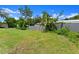 View of lush green backyard with mature trees and perimeter wood fence at 560 Sumner Ave, Orange City, FL 32763