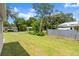 View of backyard with lush green lawn and mature trees bordering the property at 560 Sumner Ave, Orange City, FL 32763