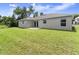 View of the home's backyard with well-maintained lawn and neutral exterior at 560 Sumner Ave, Orange City, FL 32763