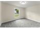 A serene bedroom with plush gray carpet offers natural light and neighborhood views at 560 Sumner Ave, Orange City, FL 32763