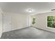 An ample bedroom features neutral walls, plush carpet, and natural light from two windows at 560 Sumner Ave, Orange City, FL 32763