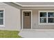 Close-up of a charming entrance with a well-lit doorway and neatly trimmed lawn at 560 Sumner Ave, Orange City, FL 32763