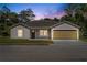 Charming single-story home featuring a well-maintained lawn and a two-car garage at dusk at 560 Sumner Ave, Orange City, FL 32763
