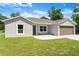 Charming one-story home with a two-car garage, well-manicured lawn, and a welcoming front entrance at 560 Sumner Ave, Orange City, FL 32763