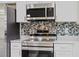 Stainless steel stove and microwave combination with decorative tiled backsplash at 560 Sumner Ave, Orange City, FL 32763