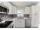 Modern kitchen with stainless steel appliances, granite counters, tile backsplash, and white cabinets at 560 Sumner Ave, Orange City, FL 32763