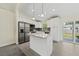 Bright kitchen boasts stainless appliances, an island, and sliding glass doors to the backyard at 560 Sumner Ave, Orange City, FL 32763