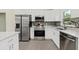 Modern kitchen with stainless steel appliances, white cabinets, granite countertops, and stylish backsplash at 560 Sumner Ave, Orange City, FL 32763