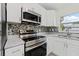 Close-up of kitchen features stainless steel stove, mosaic backsplash, and white cabinetry at 560 Sumner Ave, Orange City, FL 32763