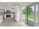 Modern kitchen with stainless appliances, white cabinets, and sliding glass door to backyard at 560 Sumner Ave, Orange City, FL 32763