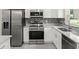 Well-equipped kitchen with stainless steel appliances, white cabinets, and designer backsplash at 560 Sumner Ave, Orange City, FL 32763