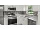Charming kitchen featuring stainless steel appliances, white cabinets, and granite countertops at 560 Sumner Ave, Orange City, FL 32763