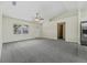 Bright, spacious living room features plush carpeting and view into hallway at 560 Sumner Ave, Orange City, FL 32763