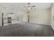 Spacious living room with a ceiling fan, carpeted floors, and an open view into the kitchen at 560 Sumner Ave, Orange City, FL 32763