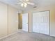 Bedroom featuring plush carpeting, lighted fan, closet, and open door to bathroom at 564 Mount Olympus Blvd, New Smyrna Beach, FL 32168