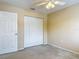 Bedroom with plush carpet, lighted ceiling fan, and large double-door closet at 564 Mount Olympus Blvd, New Smyrna Beach, FL 32168