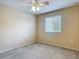 Cozy bedroom features plush carpeting, lighted ceiling fan, and large window at 564 Mount Olympus Blvd, New Smyrna Beach, FL 32168
