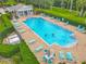 Aerial view of a sparkling community pool with lounge chairs, landscaping, and a cozy pool house at 564 Mount Olympus Blvd, New Smyrna Beach, FL 32168