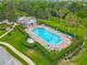 Aerial view of sparkling community pool with ample lounge chairs, lush landscaping, and convenient pool house at 564 Mount Olympus Blvd, New Smyrna Beach, FL 32168