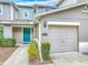 Charming townhome featuring a teal front door, one-car garage, and neat landscaping at 564 Mount Olympus Blvd, New Smyrna Beach, FL 32168