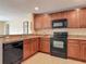 Functional kitchen equipped with black appliances and wood cabinets at 564 Mount Olympus Blvd, New Smyrna Beach, FL 32168