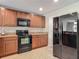 Kitchen with black appliances, wood cabinetry and beige countertops at 564 Mount Olympus Blvd, New Smyrna Beach, FL 32168