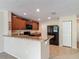 Kitchen with stainless steel refrigerator and breakfast bar overlooking the living area at 564 Mount Olympus Blvd, New Smyrna Beach, FL 32168