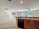 Kitchen with stainless steel sink and breakfast bar overlooking living room at 564 Mount Olympus Blvd, New Smyrna Beach, FL 32168